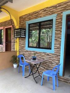 einen Tisch und zwei blaue Stühle auf einer Terrasse in der Unterkunft Friendly Transient House in Puerto Princesa