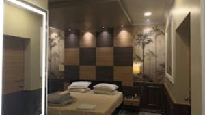 een slaapkamer met een bed en een spiegel in een kamer bij Hotel Ashoka Cuttack in Cuttack