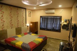 een slaapkamer met een bed met een kleurrijke deken bij Hotel Ashoka Cuttack in Cuttack