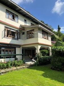 a house with a green yard in front of it at Mintokling Guest House in Gangtok