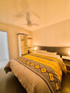 um quarto com uma cama com um cobertor amarelo em APT° Aconchegante Acqua Park em Pelotas