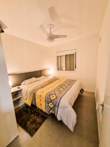 1 dormitorio con 1 cama y ventilador de techo en APT° Aconchegante Acqua Park, en Pelotas