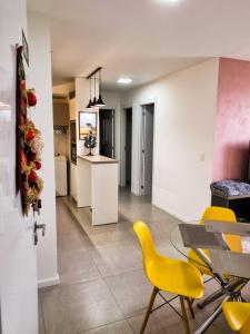 ein Wohnzimmer mit einem Tisch und gelben Stühlen in der Unterkunft APT° Aconchegante Acqua Park in Pelotas