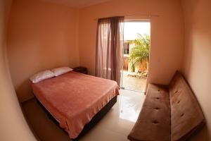 a small bedroom with a bed and a window at Residencial Beija-Flor in Palhoça