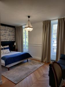 a bedroom with a blue bed and a chandelier at Château De La Bûcherie in Saint-Cyr-en-Arthies
