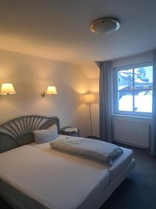 a bedroom with a bed with a large window at Hotel zur Altstadt - Garni in Lüdenscheid