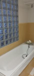 d'une baignoire avec du carrelage bleu en verre sur le mur. dans l'établissement As pitas, à Tapia de Casariego