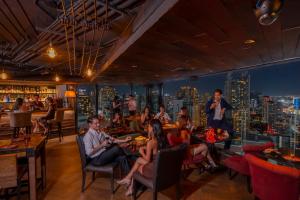 eine Gruppe von Personen, die in einem Restaurant sitzen in der Unterkunft The Continent Hotel Sukhumvit - Asok BTS Bangkok by Compass Hospitality in Bangkok