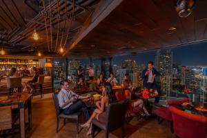 un grupo de personas sentadas en un restaurante en The Continent Hotel Sukhumvit - Asok BTS Bangkok by Compass Hospitality, en Bangkok