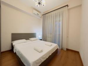a bedroom with a large bed with white sheets at Apartments by GR Yerevan in the city centre in Yerevan