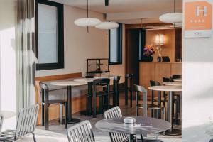 un groupe de tables et de chaises dans un restaurant dans l'établissement Hotel Moderne, à Porto-Vecchio
