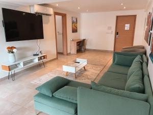 a living room with a couch and a flat screen tv at Sky Suites in Accra