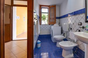 a blue and white bathroom with a toilet and a sink at Case Vacanze Castellana Iris in Sciacca