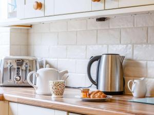 a kitchen counter with a coffee pot and croissants at 3 Bed in Torquay 82959 in Torquay