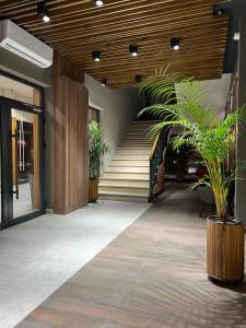 a lobby with stairs and a potted plant at Kopaonik Apart Bela Reka Brzece in Brzeće