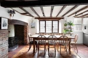 a dining room with a table and chairs and a fireplace at The Bank House in Ditchling