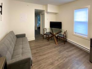 a living room with a couch and a table and a television at Calming 1bedroom Units With Balcony And City View in Edmonton