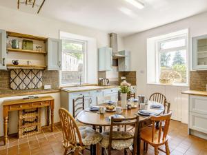 uma cozinha com uma mesa e cadeiras e uma lareira em 5 Bed in Achnasheen 83017 em Achnasheen