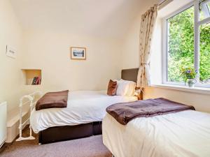 two beds in a room with a window at 2 bed in Shap SZ005 in Shap