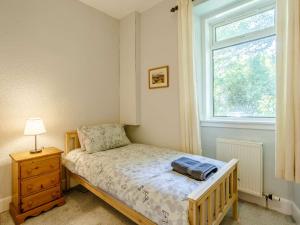 um pequeno quarto com uma cama e uma janela em 5 Bed in Achnasheen 83017 em Achnasheen