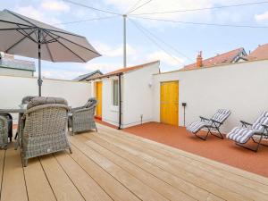 a patio with a table and chairs and an umbrella at 1 Bed in Llandudno 83621 in Llandudno