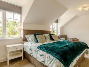 a bedroom with a bed with a green blanket on it at 3 bed in Wedmore 83630 in Edington