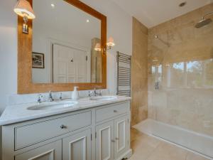 a bathroom with two sinks and a mirror and a tub at 9 Bed in Cockermouth SZ570 in Bridekirk