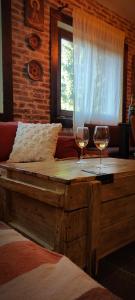 a bedroom with two glasses of wine on a bed at Uki & Sofi mountain house in Kopaonik