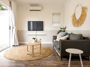 een woonkamer met een bank en een tafel bij Secure, Peaceful Modern Cottage for Two in Durban