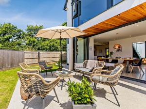 a patio with chairs and a table and an umbrella at 4 Bed in Bude 83619 in Stratton