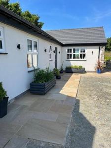 a white house with a patio in front of it at Superb Location - 'The Annexe' - at Ty Moel Isaf in Amlwch