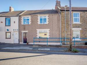 a brick house with a blue bench in front of it at 2 Bed in Newbiggin-by-the-Sea 83568 in Newbiggin-by-the-Sea