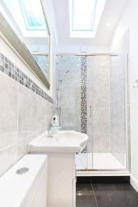 y baño blanco con lavabo y ducha. en Superb Location - 'The Annexe' - at Ty Moel Isaf, en Amlwch
