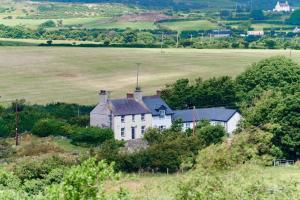 a white house in the middle of a field at Superb Location - 'The Annexe' - at Ty Moel Isaf in Amlwch