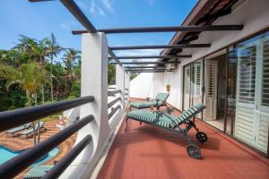 a balcony with green chairs and a pool at Lalaria Ocean Villa suite 5 in Ballito