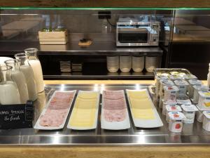 a kitchen with meat and other food items on display at ibis budget Madrid Aeropuerto in Madrid