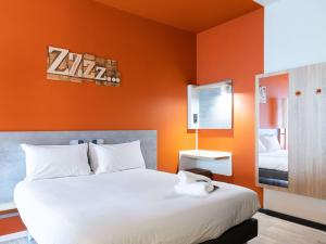 1 dormitorio con 1 cama grande y pared de color naranja en ibis budget Madrid Aeropuerto, en Madrid