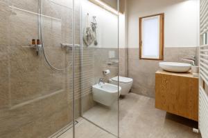 a bathroom with a shower and a toilet and a sink at Casa Al Rin in Valdidentro