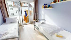 ein Krankenhauszimmer mit 2 Betten und einem Fenster in der Unterkunft Grüntal-Residenz Haus II App. 5 in Grömitz