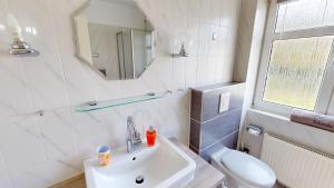 グレーミッツにあるGrüntal-Residenz Haus II App. 5のバスルーム(洗面台、トイレ、鏡付)
