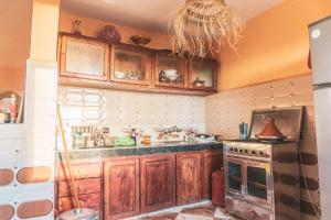 a kitchen with wooden cabinets and a stove top oven at Be Free Surfhouse in Tamri