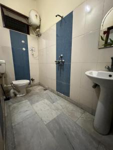 a bathroom with a toilet and a sink at Shastreey Sangeet Nivas in Vrindāvan