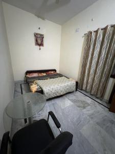 a small room with a bed and a table at Shastreey Sangeet Nivas in Vrindāvan