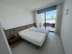 a bedroom with a bed and a view of the ocean at Bungalow de lujo 5* 1ª LÍNEA Playa San Juan in Alicante +24 photos
