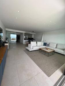 a living room with white couches and a table at Bungalow de lujo 5* 1ª LÍNEA Playa San Juan in Alicante