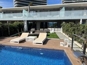 a house with a swimming pool next to a building at Bungalow de lujo 5* 1ª LÍNEA Playa San Juan in Alicante