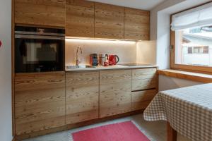a kitchen with wooden cabinets and a sink at Casa Al Rin in Valdidentro