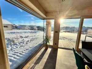 a screened porch with a view of a snow covered yard at Magnifique villa nature le Bois d'Aura in Luisans