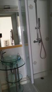 ein Bad mit einem Glastisch und einer Dusche in der Unterkunft Villa vacances N°23 à 100 mètres de la plage in Saint-Cyprien