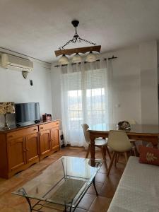 a living room with a dining room table and a kitchen at Apartamentos Fuente La Raja in La Iruela